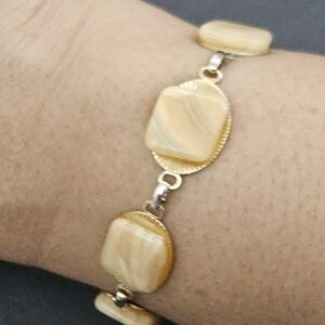 Bracelet with cream agate pillow-shaped stones on circular goldtone links